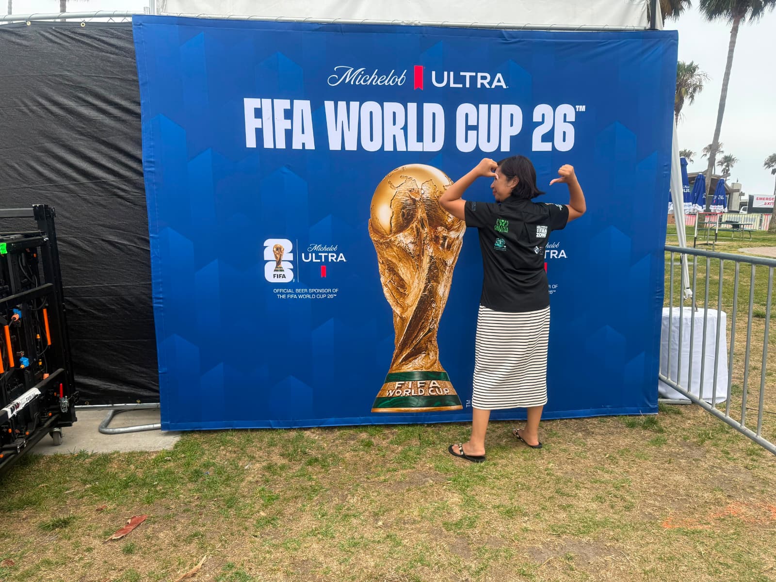 Event attendee posing beside the FIFA World Cup 2026 display at Venice Beach